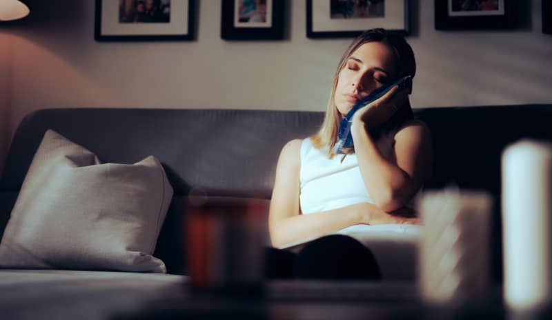 Chica aliviando el dolor después de una extracción de muela del juicio