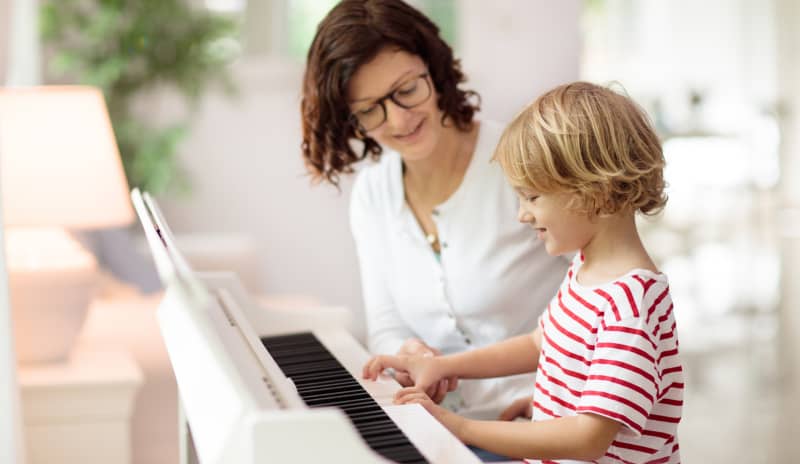 Niño realizando musicoterapia con piano.