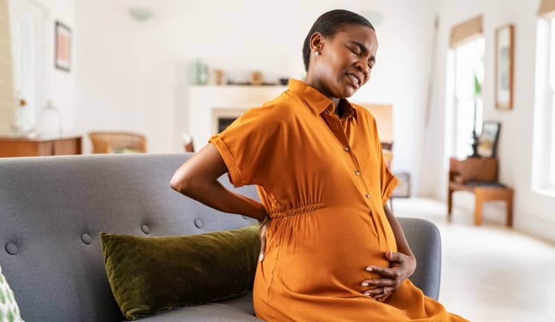mujer con dolor lumbar por cólicos en el embarazo
