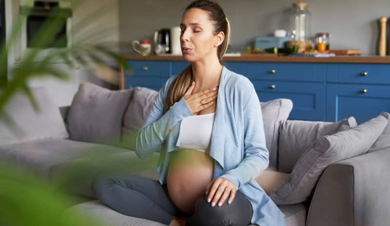 Mujer embarazada practicando respiración diafragmática para prevenir diástasis abdominal como consecuencia del embarazo