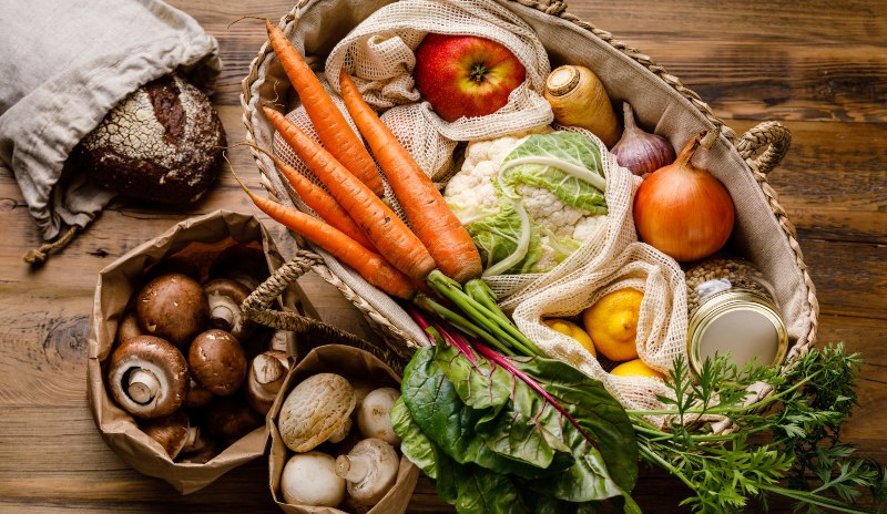 Cesta con verduras frescas, frutas, pan integral y otros alimentos naturales, imagen relacionada con una dieta de 1500 calorías recomendada por un endocrino para una alimentación equilibrada