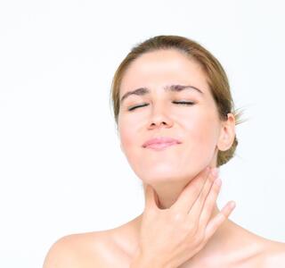 mujer con dolor en las cuerdas vocales