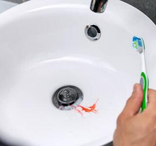 Hombre con sangrado de la encía mientras se cepilla los dientes