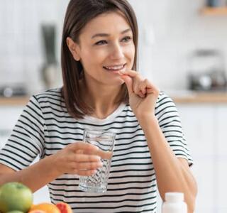 mujer tomando complementos alimenticios