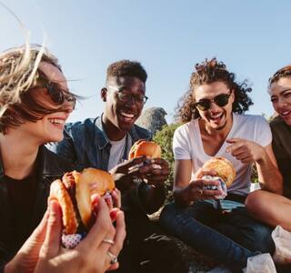 jóvenes comiendo contentos por tener un seguro para jóvenes contratado
