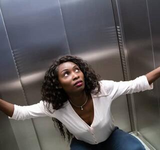 Mujer con claustrofobia dentro de un ascensor