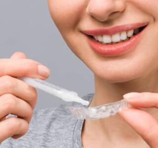 primer plano de una chica blanqueando sus dientes