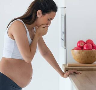 mujer joven embarazada con náuseas severas