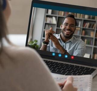 Pareja conversando por videollamada en un ordenador desde sus respectivos hogares, representación del modelo de relación living apart together.