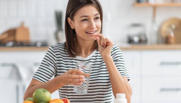 mujer tomando complementos alimenticios