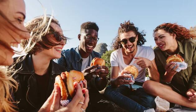 jóvenes comiendo contentos por tener un seguro para jóvenes contratado