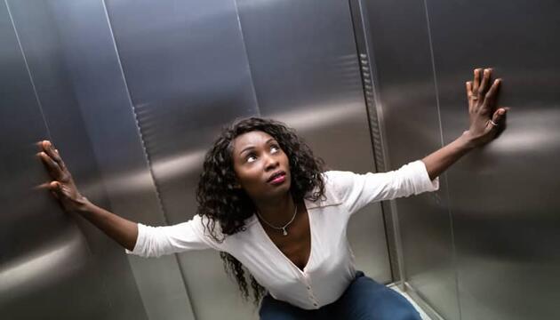 Mujer con claustrofobia dentro de un ascensor