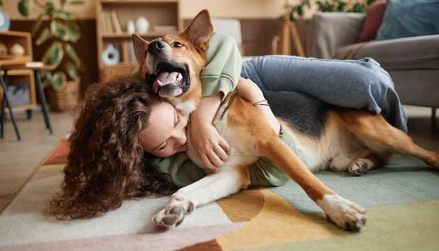 Chica feliz con su perro por tener un seguro obligatorio para mascotas