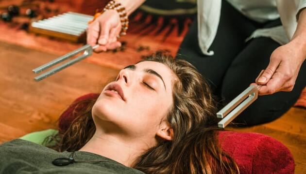 Mujer relajándose con musicoterapia.