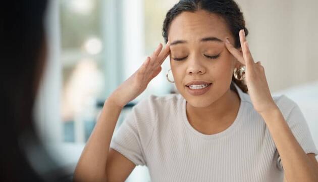 Chica con los ojos cerrados y las manos en las sienes señal de intentar concentrarse debido a su trastorno obsesivo compulsivo