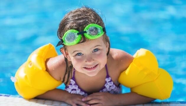 Ejercicios para mantenerse activo en el agua niña con manguitos